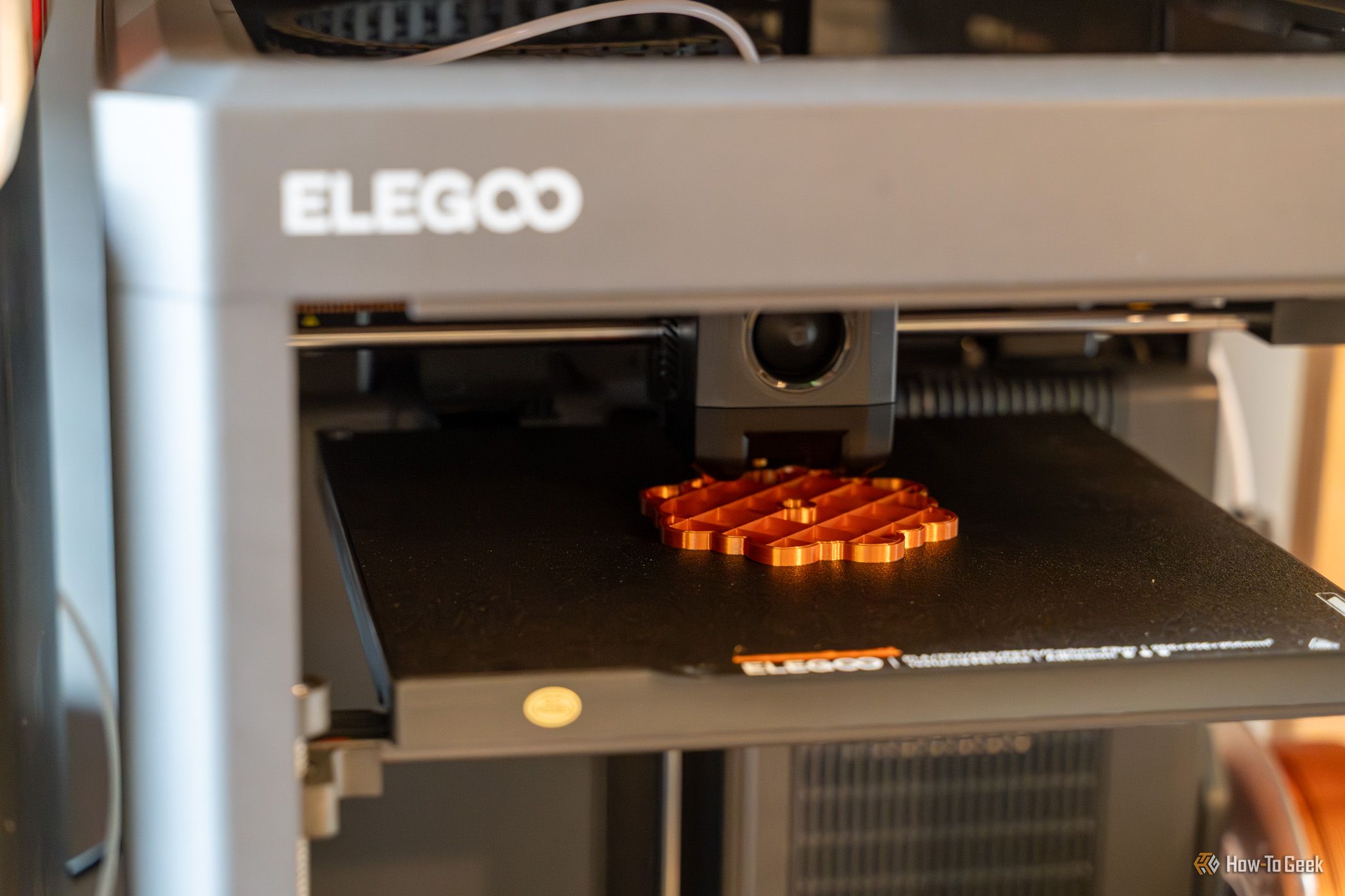 Печать оранжевой геометрической модели на текстурированной платформе принтера Elegoo Centauri 2