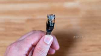 Hand holding a flat Ethernet cable.