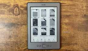 Kindle 4 running KOReader Zen UI library grid view showing book covers with the bottom navigation bar for Library Authors Series Home Continue and Favorites.