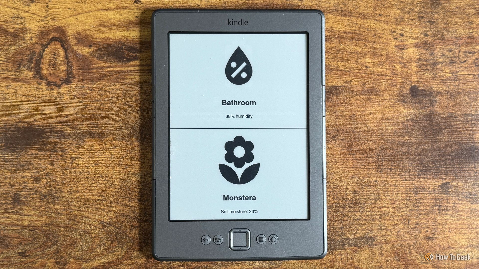 Kindle Eink display showing a Home Assistant dashboard with Bathroom humidity at 68 percent and Monstera soil moisture at 23 percent.