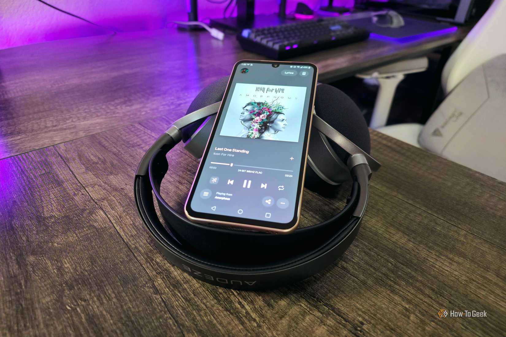 An LG V60 ThinQ smartphone sitting on top of Audeze LCD-S20 headphones, showing "Last One Standing" by Icon for Hire playing via TIDAL.