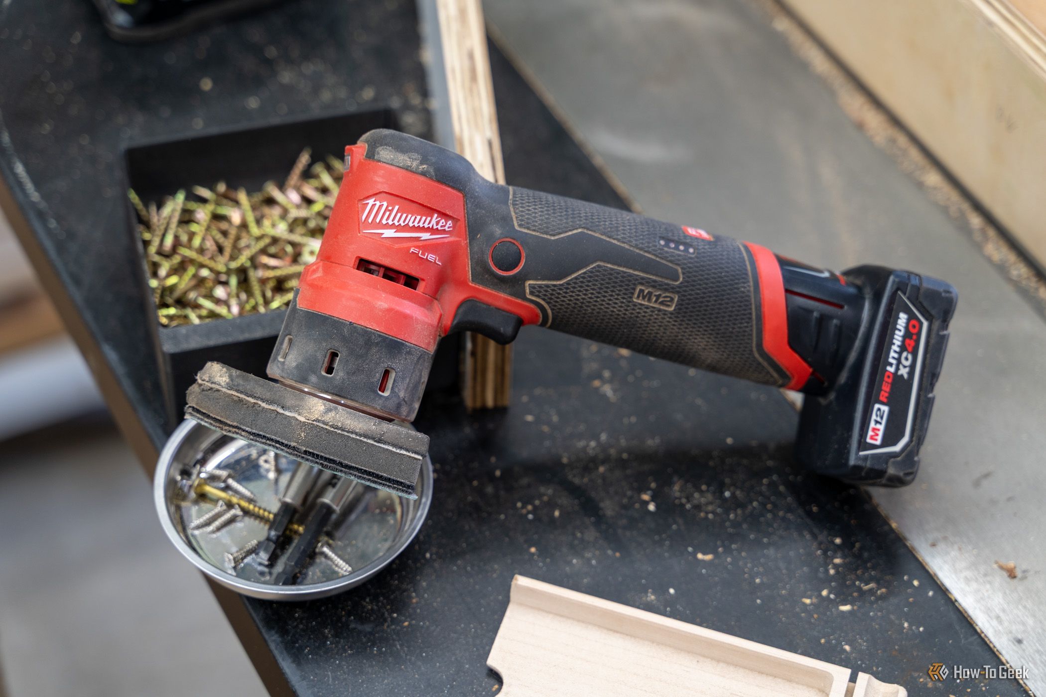 Milwaukee M12 FUEL Orbital Detail Sander overhead side view on workshop bench.
