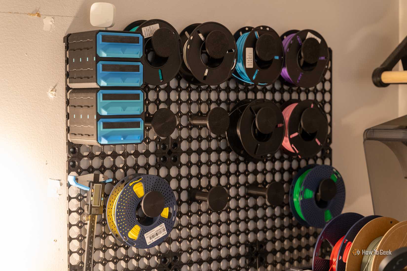 MultiBoard wall organizer with filament spools and storage bins.