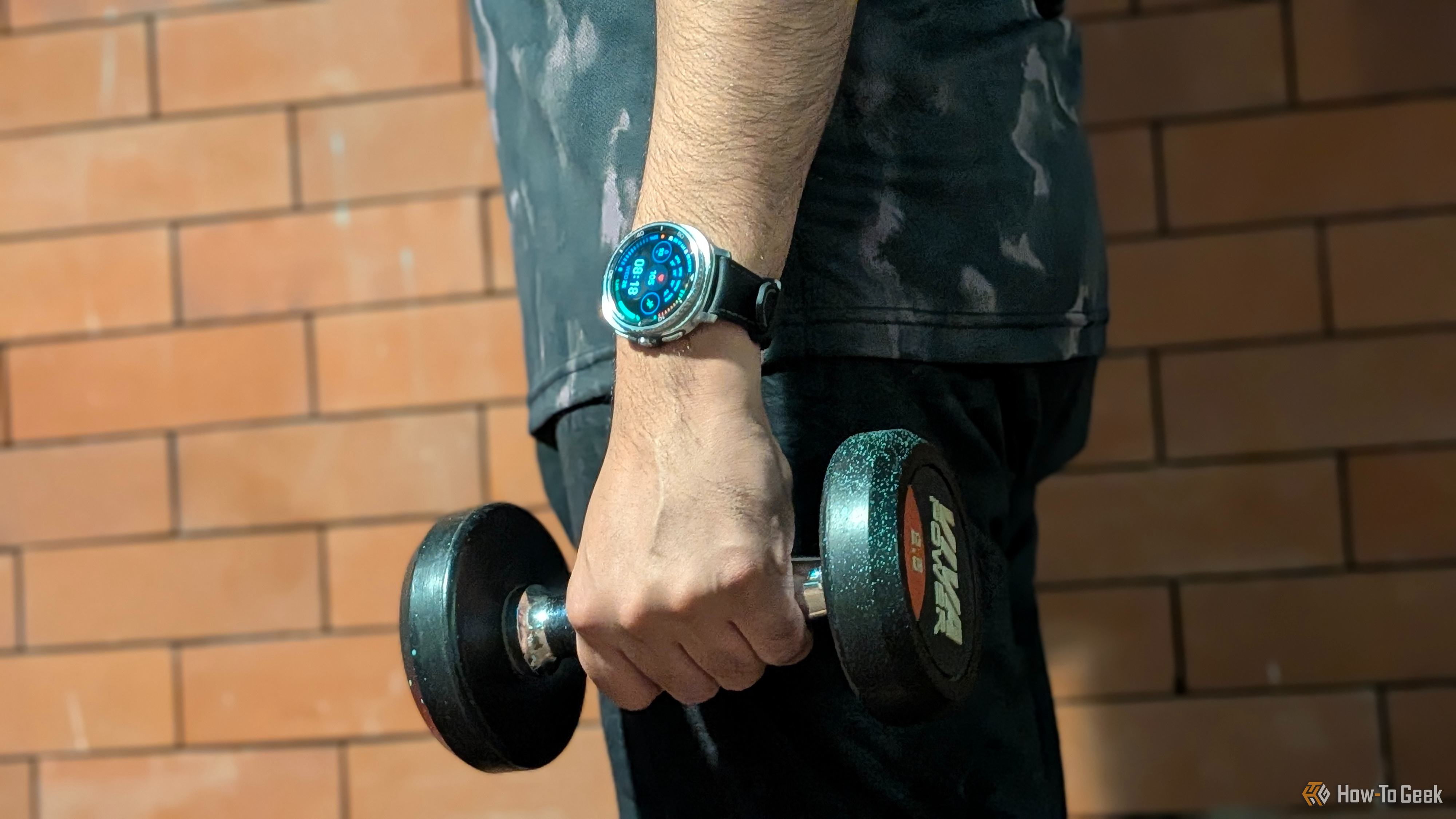 My hand holding a dumb bell in the gym with a dense health data watchface on my Galaxy Watch 8 Classic.