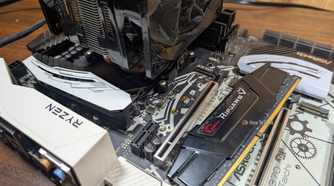 A stick of DDR4 laying on an old motherboard.