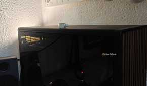 A tiny USB drive on top of a desktop PC.