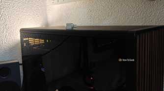 A tiny USB drive on top of a desktop PC.