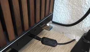A tiny USB drive plugged into the USB-C port of a desktop computer.