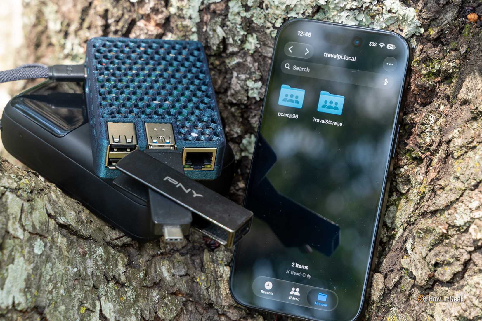 TravelPi Raspberry Pi NAS outdoor close-up with iPhone Files app and PNY USB drives.