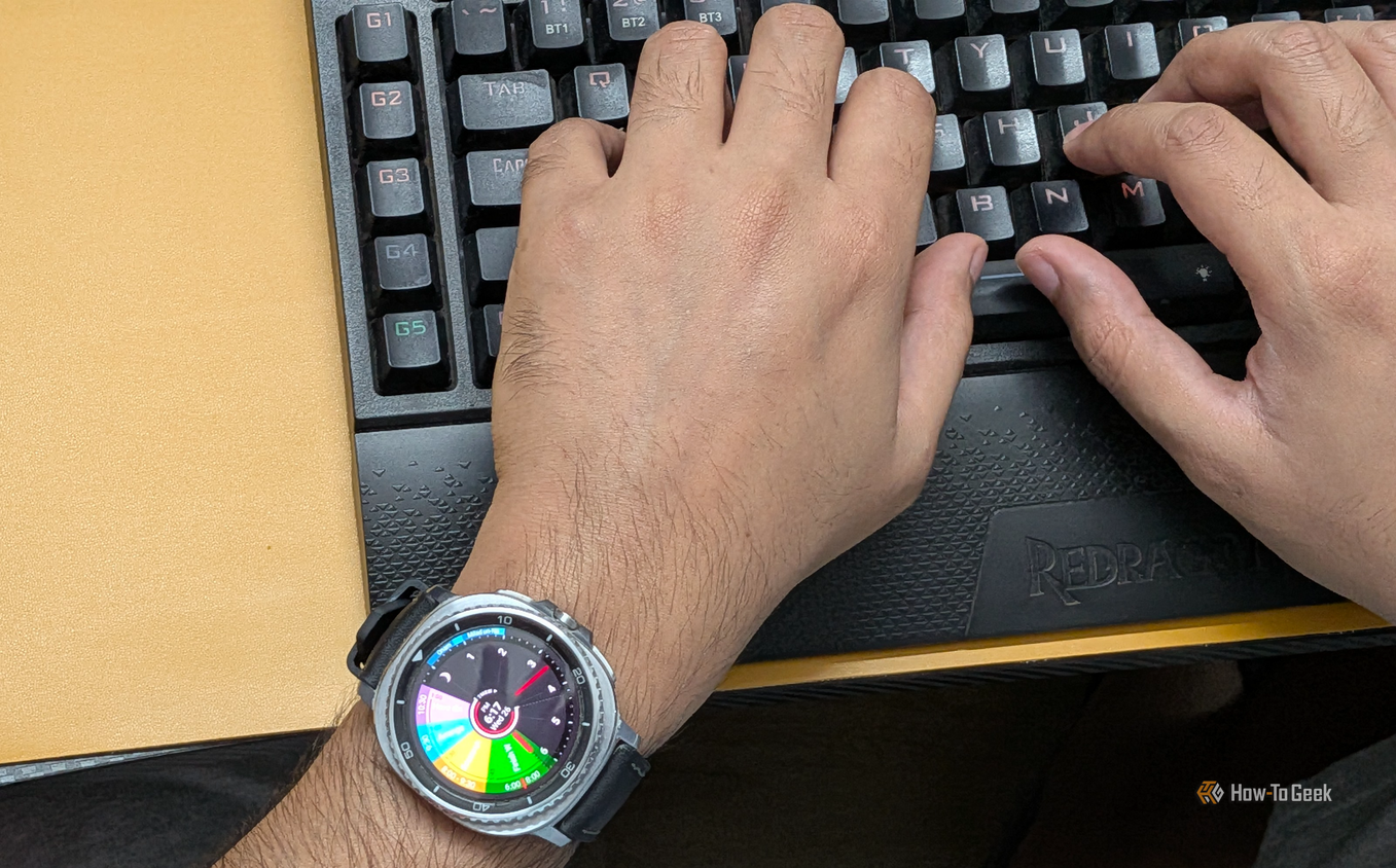 Typing on a keyboard wearing a Galaxy Watch 8 Classic with Sectograph as watch face.