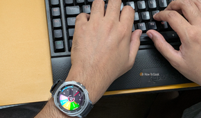 Typing on a keyboard wearing a Galaxy Watch 8 Classic with Sectograph as watch face.