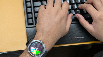 Typing on a keyboard wearing a Galaxy Watch 8 Classic with Sectograph as watch face.