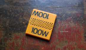 3D printed 100W orange cable clip on a table.
