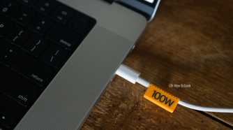 3D printed 100W orange cable clip plugged into a laptop.