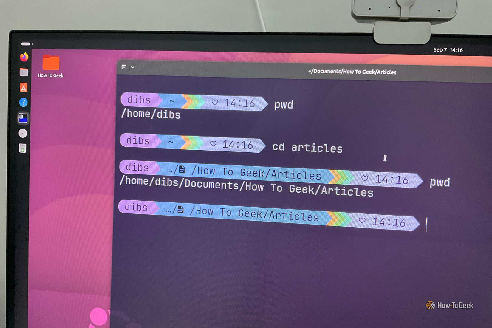 A computer monitor with Ubuntu running and the terminal showing cd and pwd command.
