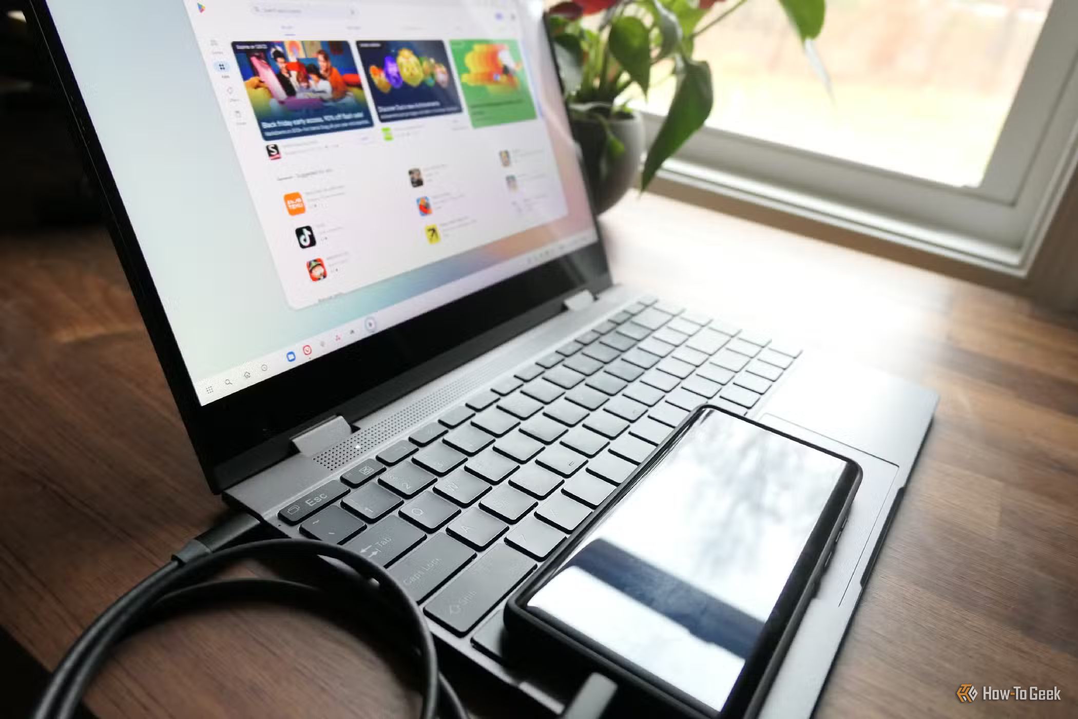 A Motorola Android phone connected to a laptop over a USB cable.