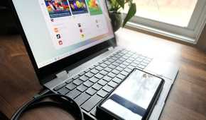 A Motorola Android phone connected to a laptop over a USB cable.