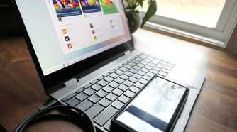 A Motorola Android phone connected to a laptop over a USB cable.