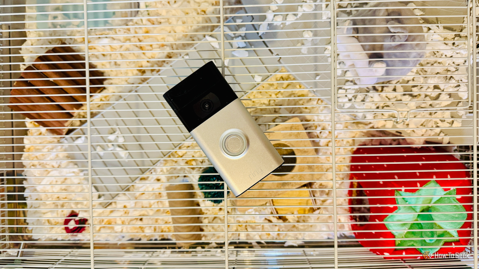 A Ring video doorbell lying on top of a hamster cage.