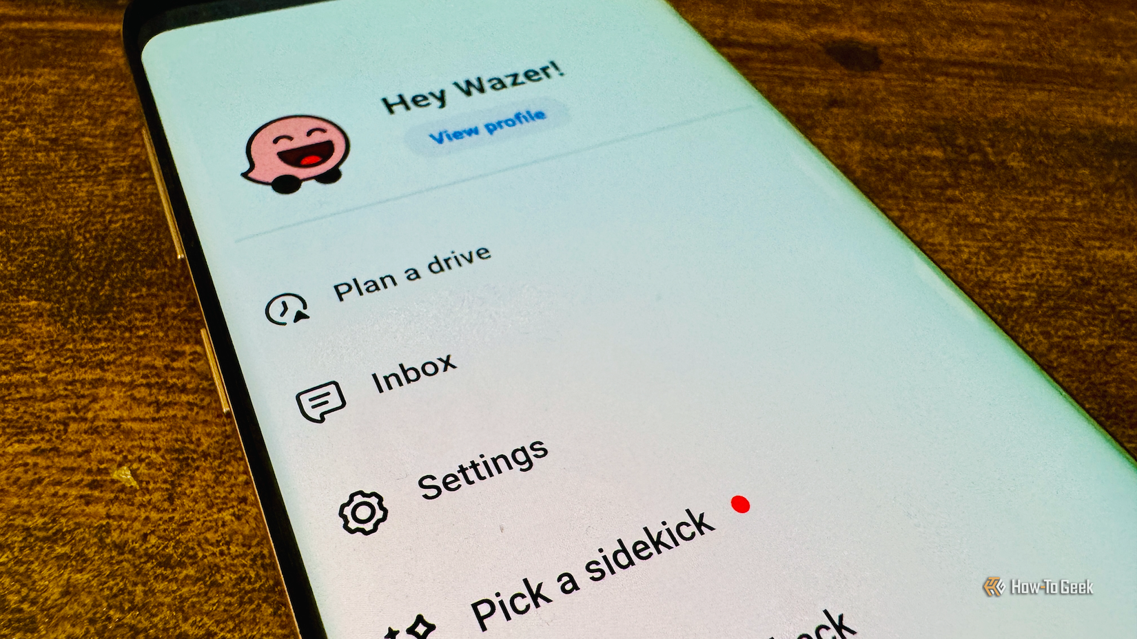 An Android phone running the Waze app showing the Settings menu option.