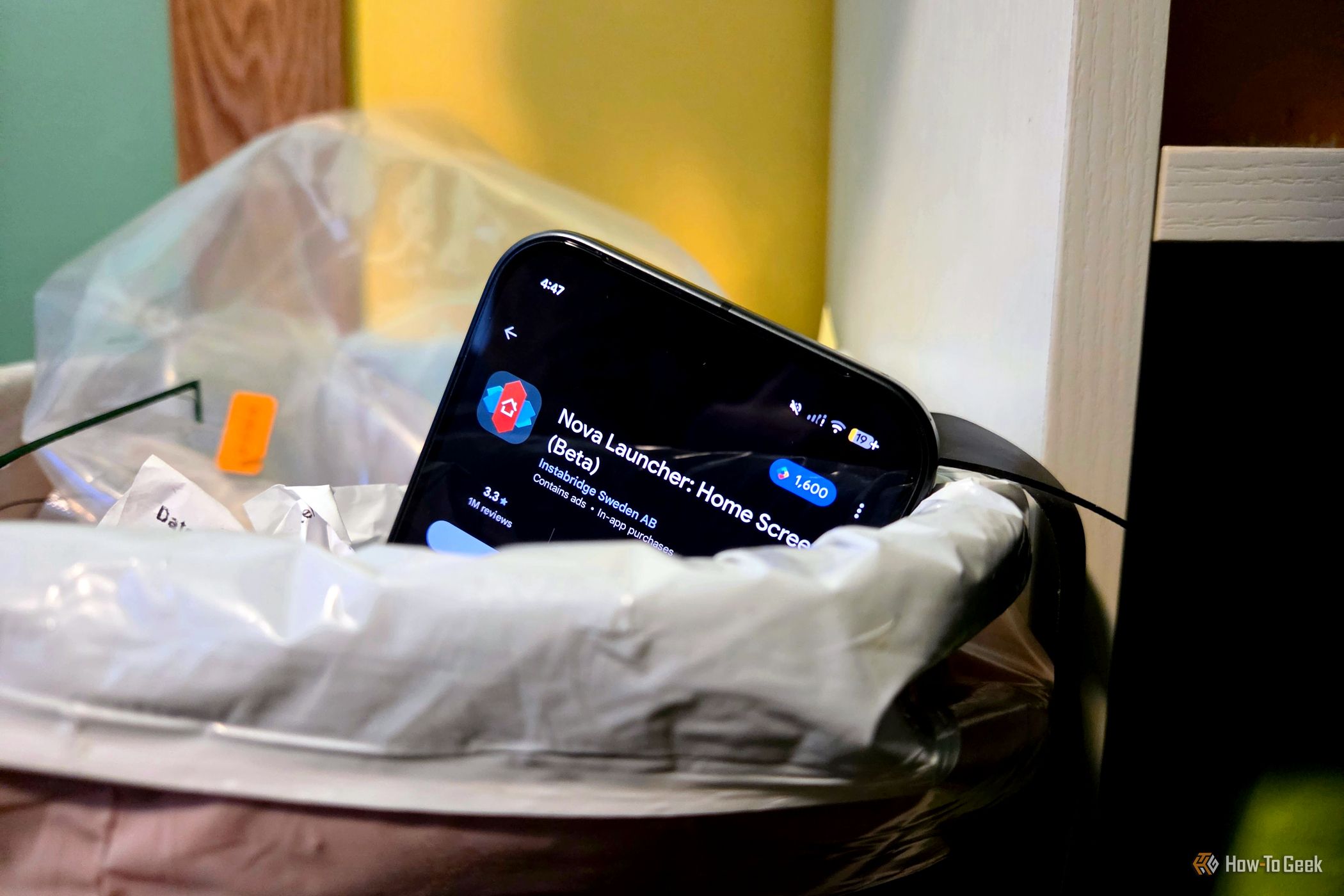 Android phone in trash with Nova Launcher on screen
