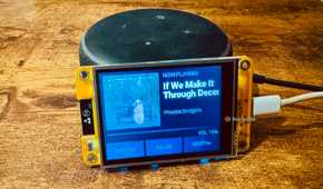 Cheap Yellow Display mounted on an Echo speaker showing a Now Playing screen for a Phoebe Bridgers track with the title cut off by the screen width.