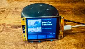 Cheap Yellow Display mounted on an Echo speaker showing a Now Playing screen for Day After Tomorrow by Phoebe Bridgers.