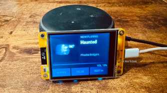 Cheap Yellow Display mounted on an Echo speaker showing a Now Playing screen for Haunted by Phoebe Bridgers.