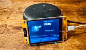 Cheap Yellow Display mounted on an Echo speaker showing a Now Playing screen for Kill Me by Phoebe Bridgers.