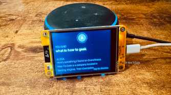 Cheap Yellow Display mounted on an Echo speaker with the blue ring lit showing the spoken command what is how to geek and Alexas response about How To Geek.