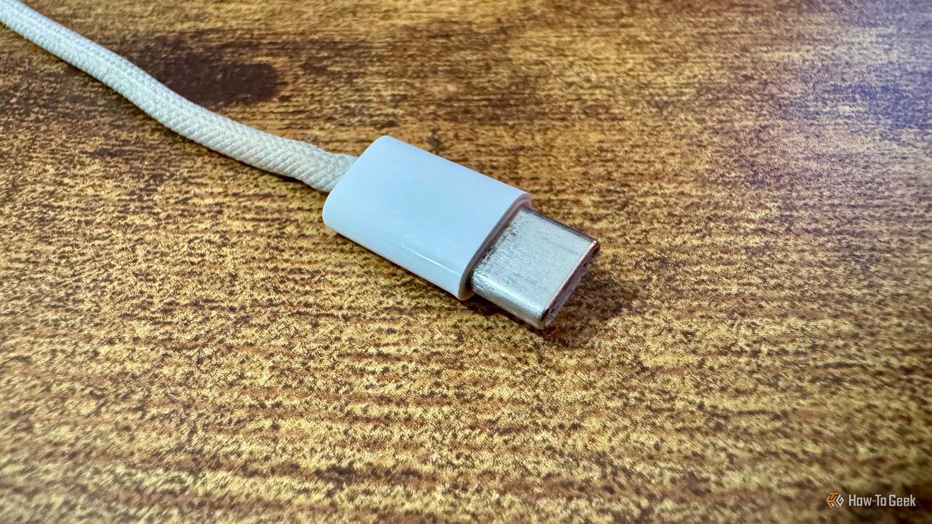 Close up of the Xteink pogo pin charging cable Type-C connector end on a wooden desk.