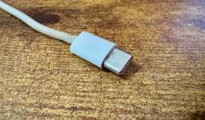 Close up of the Xteink pogo pin charging cable Type-C connector end on a wooden desk.