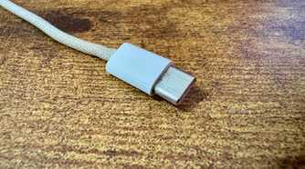 Close up of the Xteink pogo pin charging cable Type-C connector end on a wooden desk.