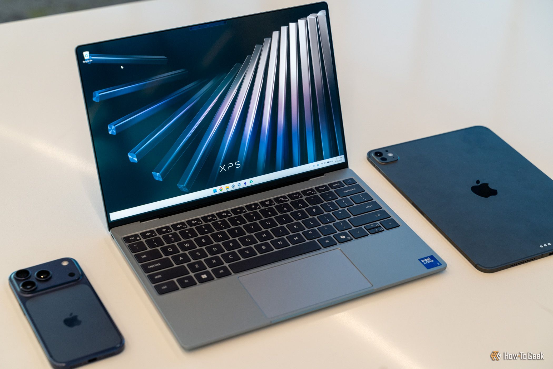 Dell XPS 13 2026 на рабочем столе рядом с iPhone и iPad