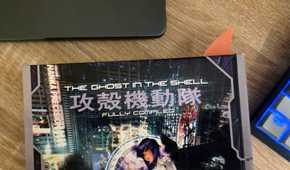Orange shark-fin bookmark protruding from a copy of The Ghost in the Shell: Fully Compiled.