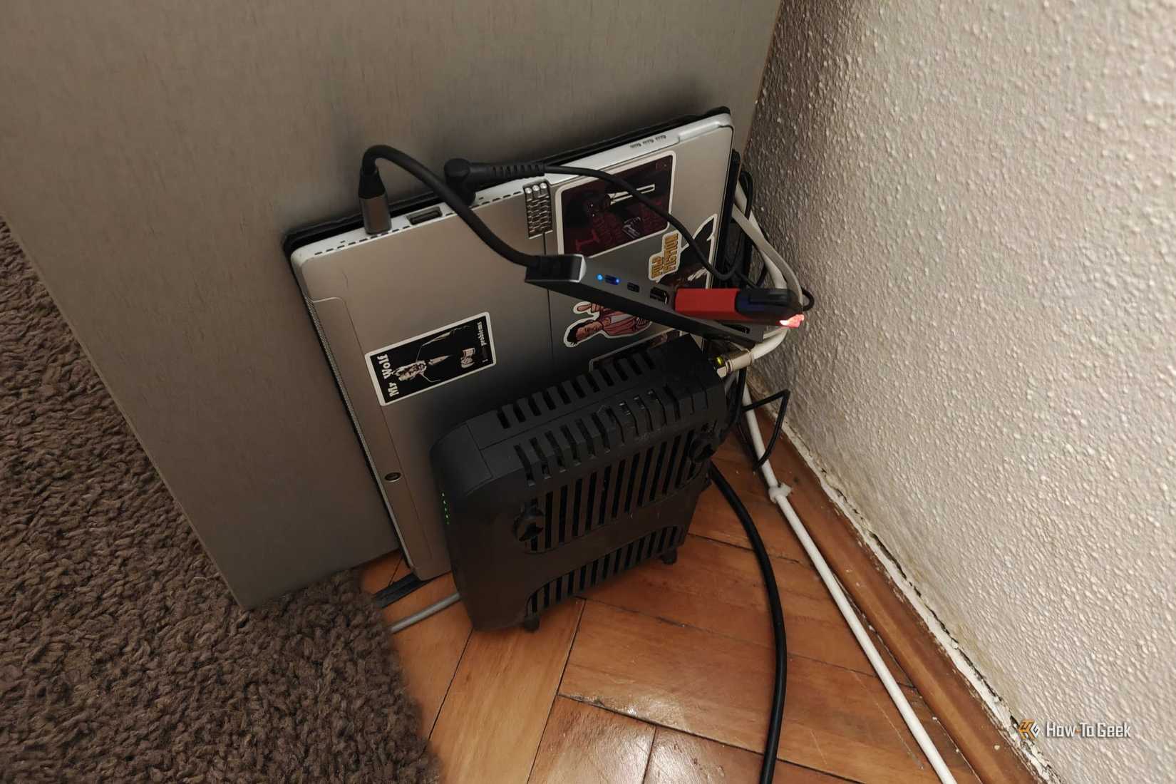 A laptop that serves as a home server next to a router.