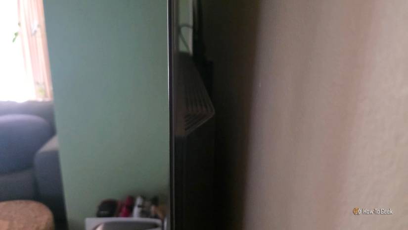 The rear of an LG OLED, showing the thick speaker enclosure next to the ultra-thin screen itself.