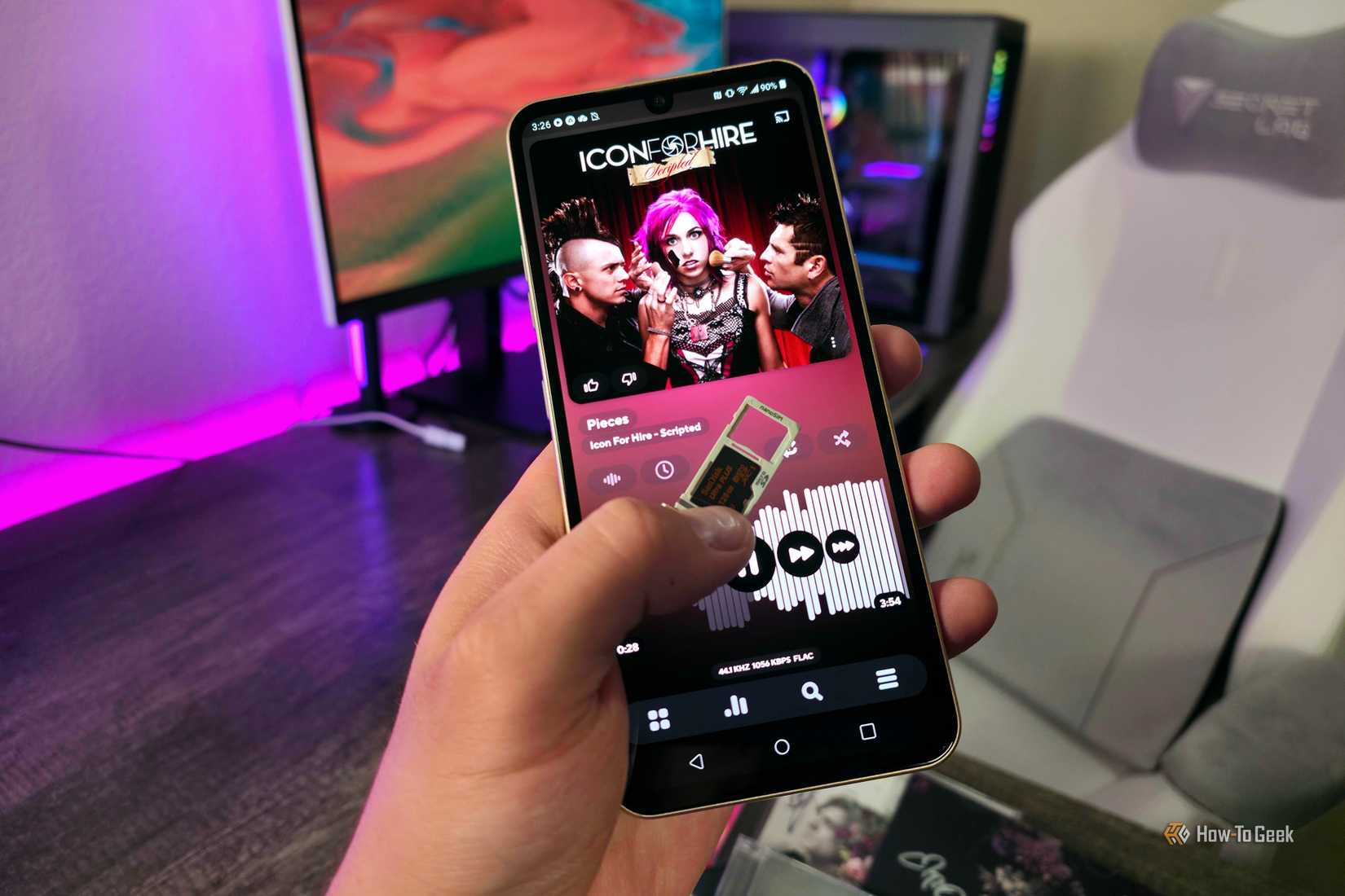 Hand holding an LG V60 ThinQ smartphone with the microSD card tray removed and a microSD card showing.