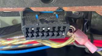 An OBD-II diagnostic port under the dashboard of a vehicle.