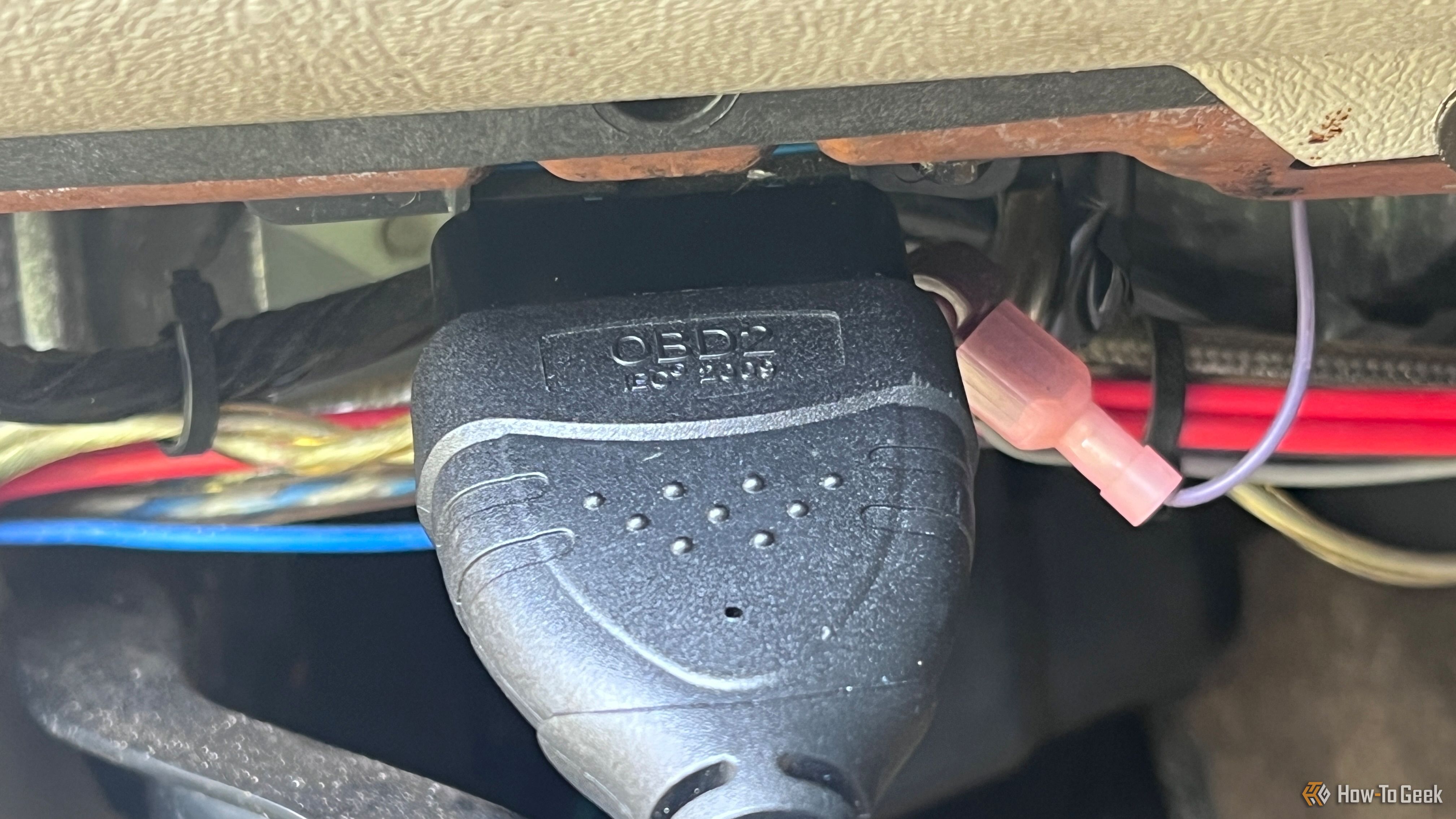 An OBD-II scanner cable plugged into the vehicle's diagnostic port.