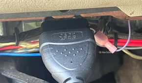 An OBD-II scanner cable plugged into the vehicle's diagnostic port.