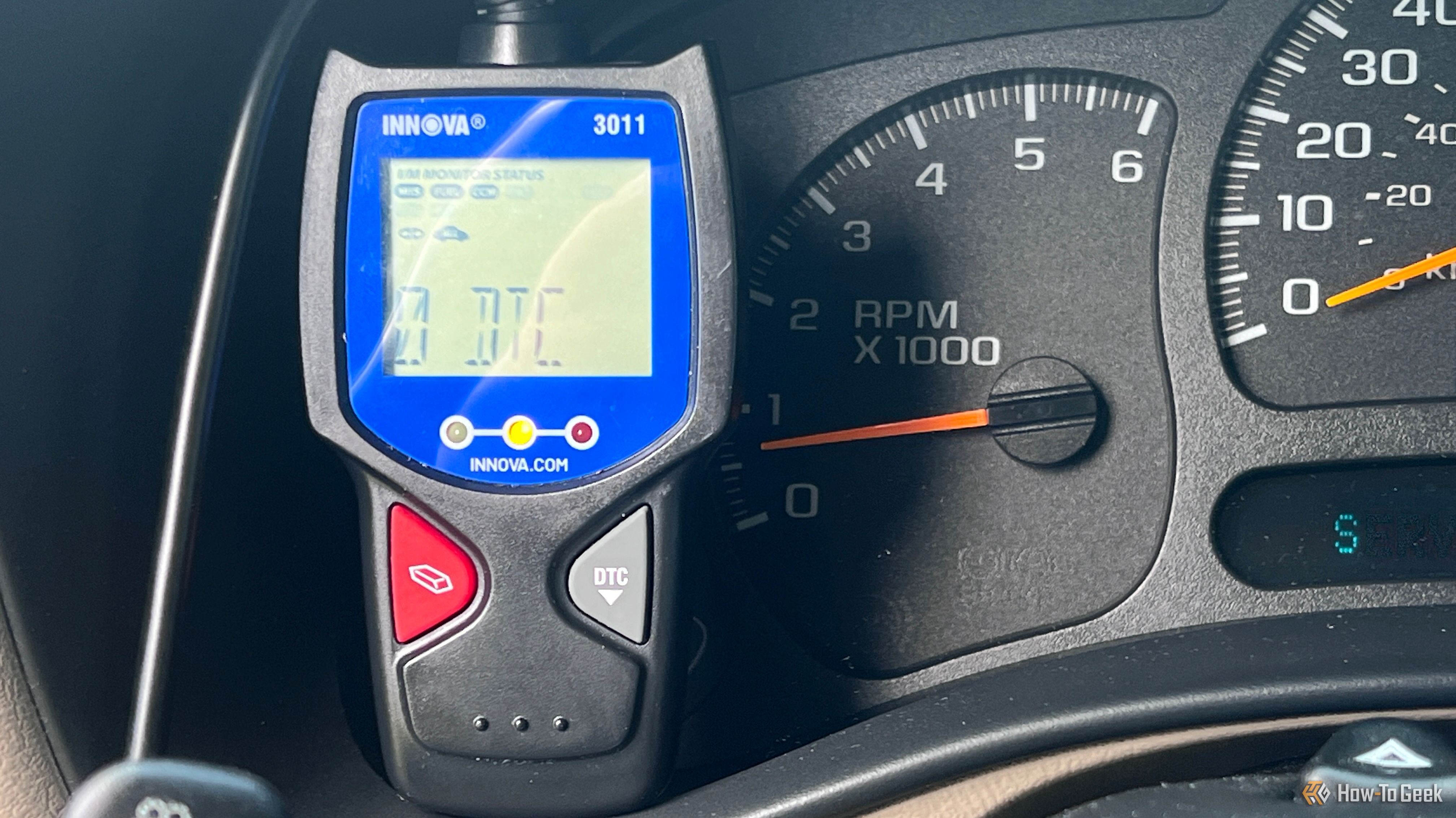An Innova 3011 OBD-II scanner displaying diagnostic information in a vehicle.