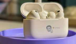 Opened AirPods Pro 3 standing up on a stand with a Memoji on it