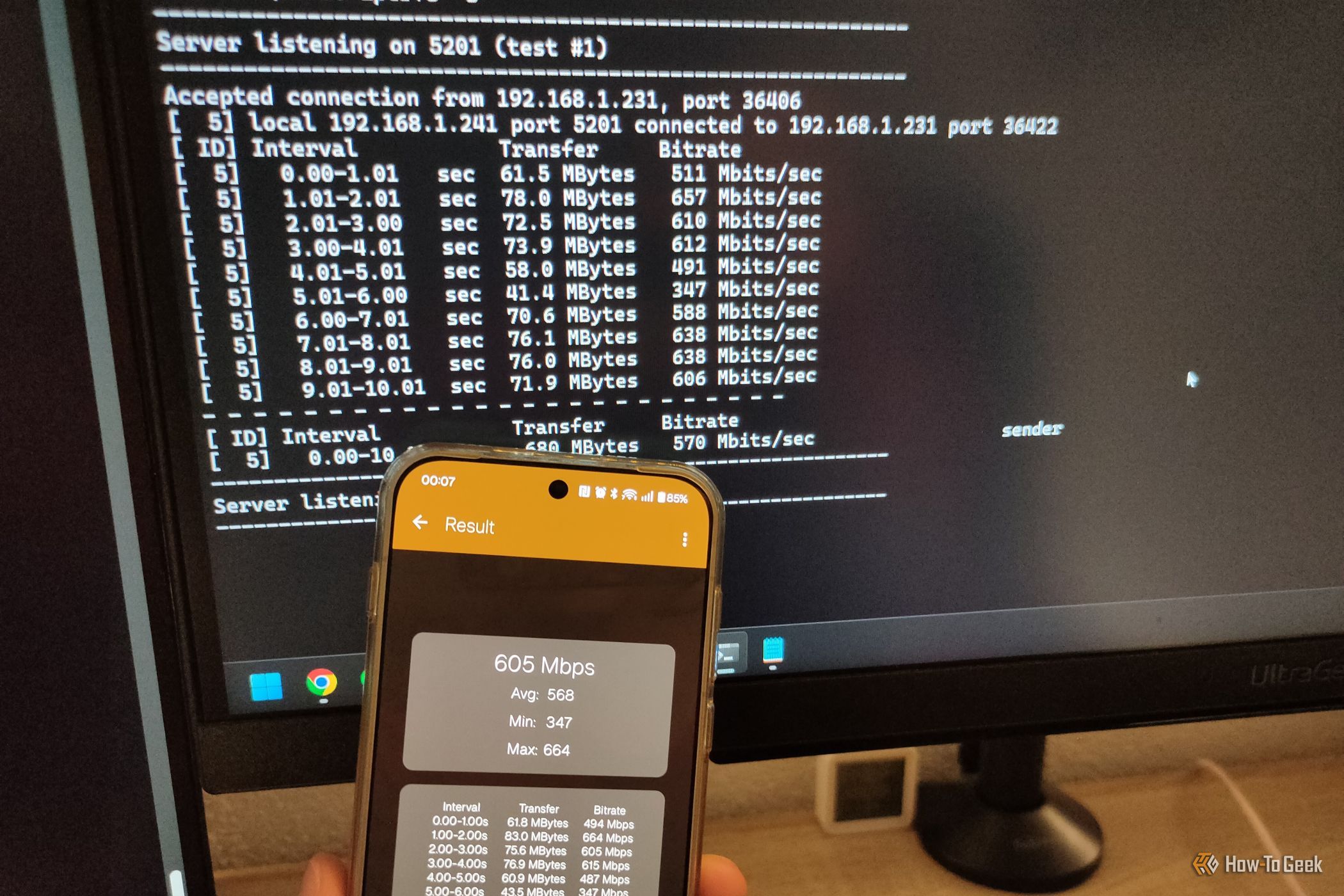 A phone with iPef3 test running with the PC in the background.