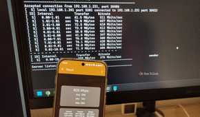 A phone with iPef3 test running with the PC in the background.