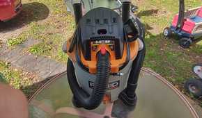 Photo of a Ridgid wet/dry vac on a table with accessories mounted