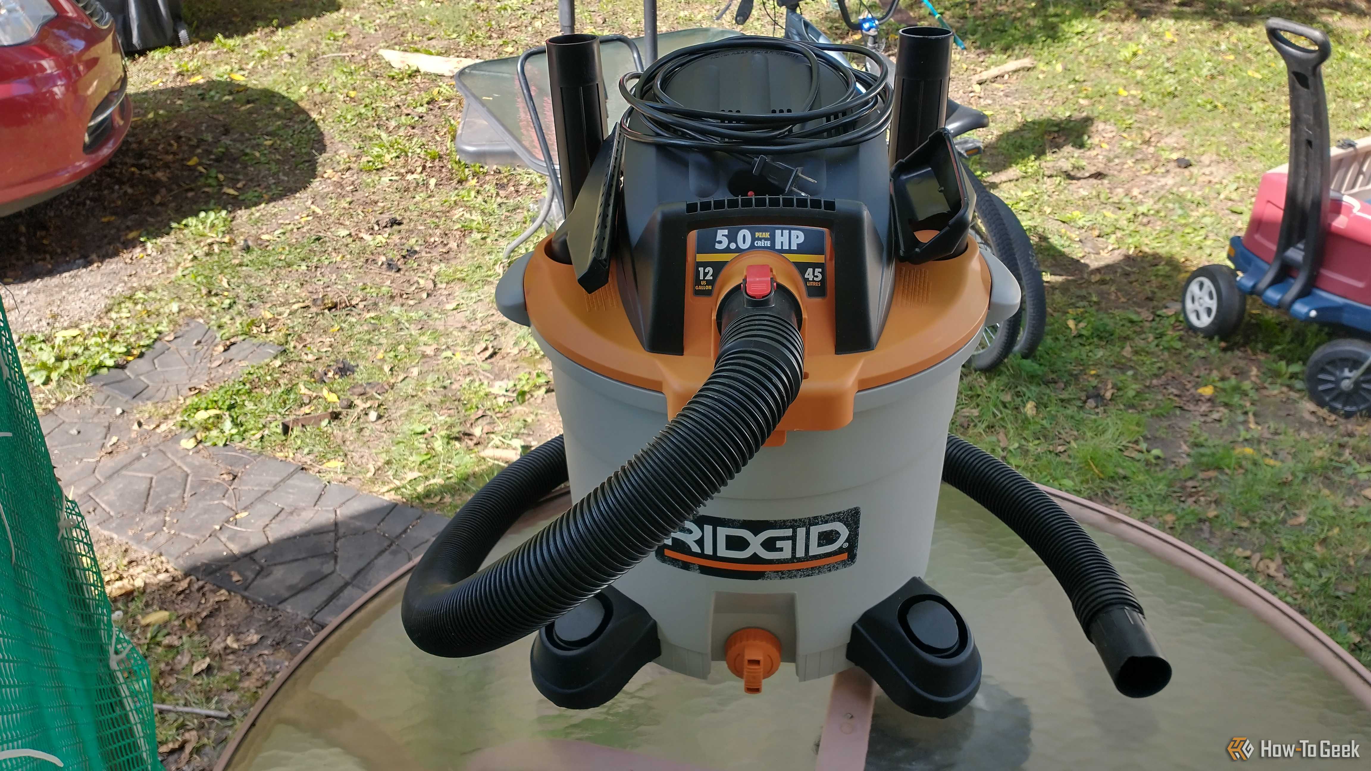 Photo of a Ridgid wet and dry vac sitting on an outdoor table with all included accessories