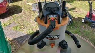 Photo of a Ridgid wet and dry vac sitting on an outdoor table with all included accessories