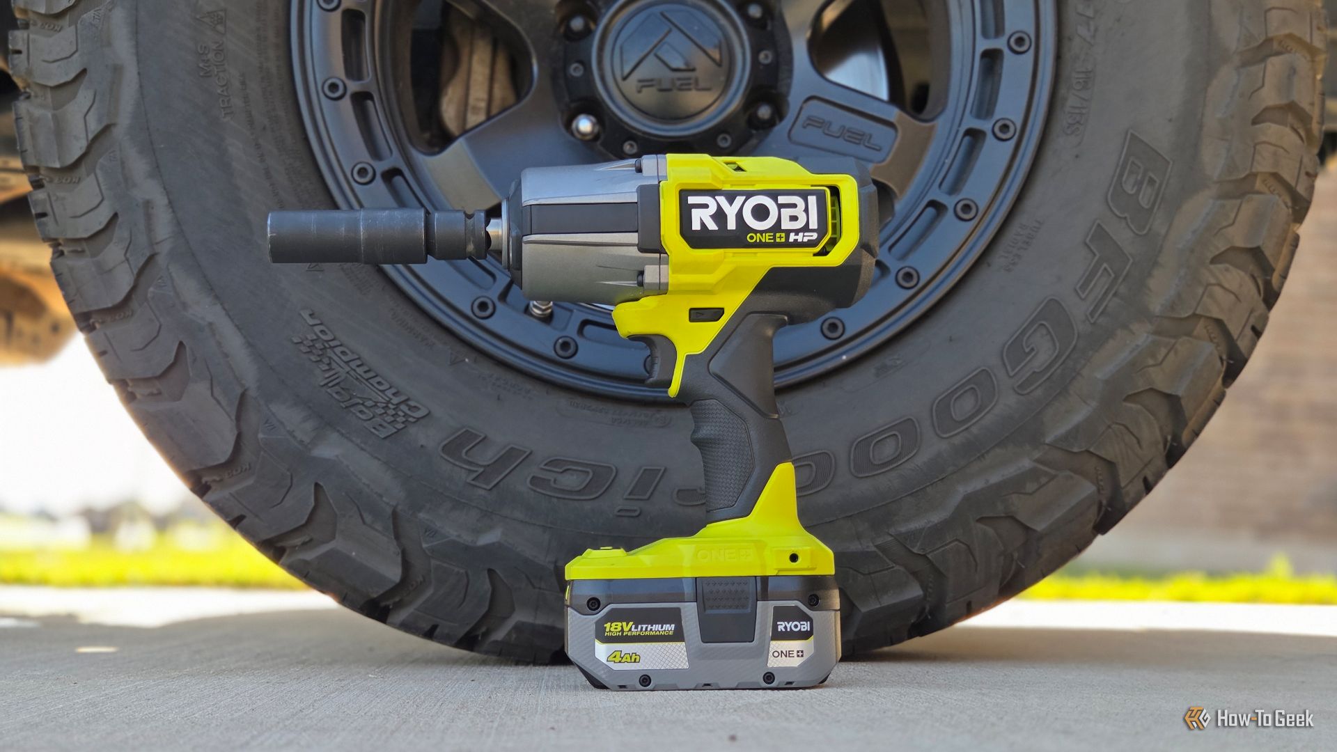 Ryobi High Torque Impact in front of a tire