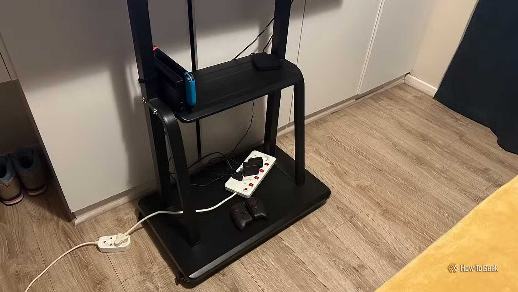 The bottom of a TV stand with a switch dock and controller.